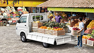 Carry-parked-in-front-of-the-fruit-market-and-a-man-is-loading-many-kinds-of-fruit-on-its-bed