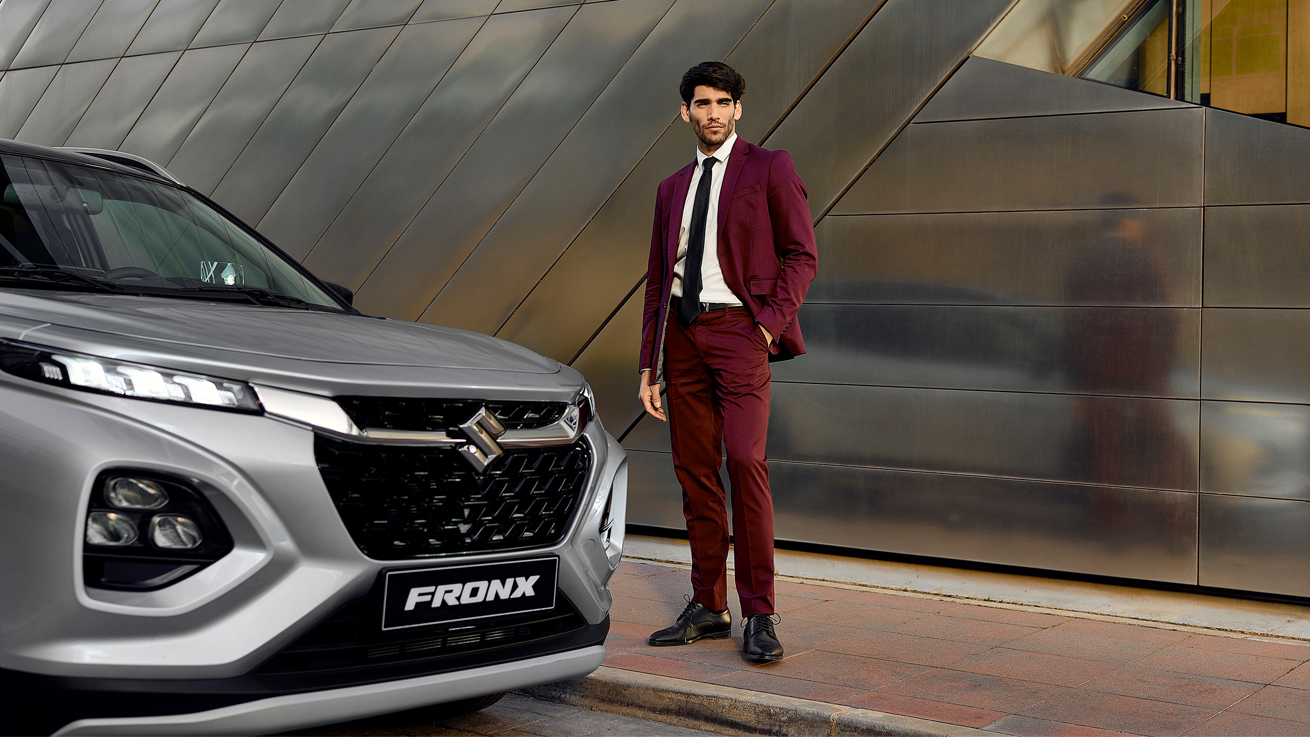 Suzuki-Fronx-male-standing-next-to-car