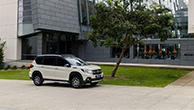 Suzuki-XL7-parked-infront-of-trees-and-building