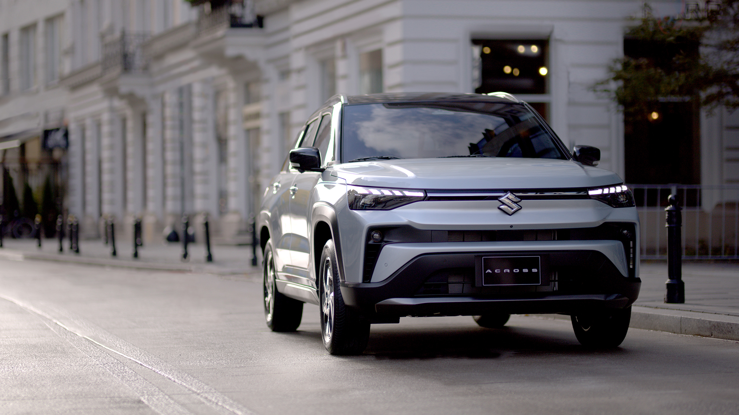 Across-silver-SUV-driving-in-urban-street-front-view