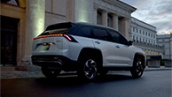 Across-silver-SUV-parked-in-urban-street-rear-view-at-dusk