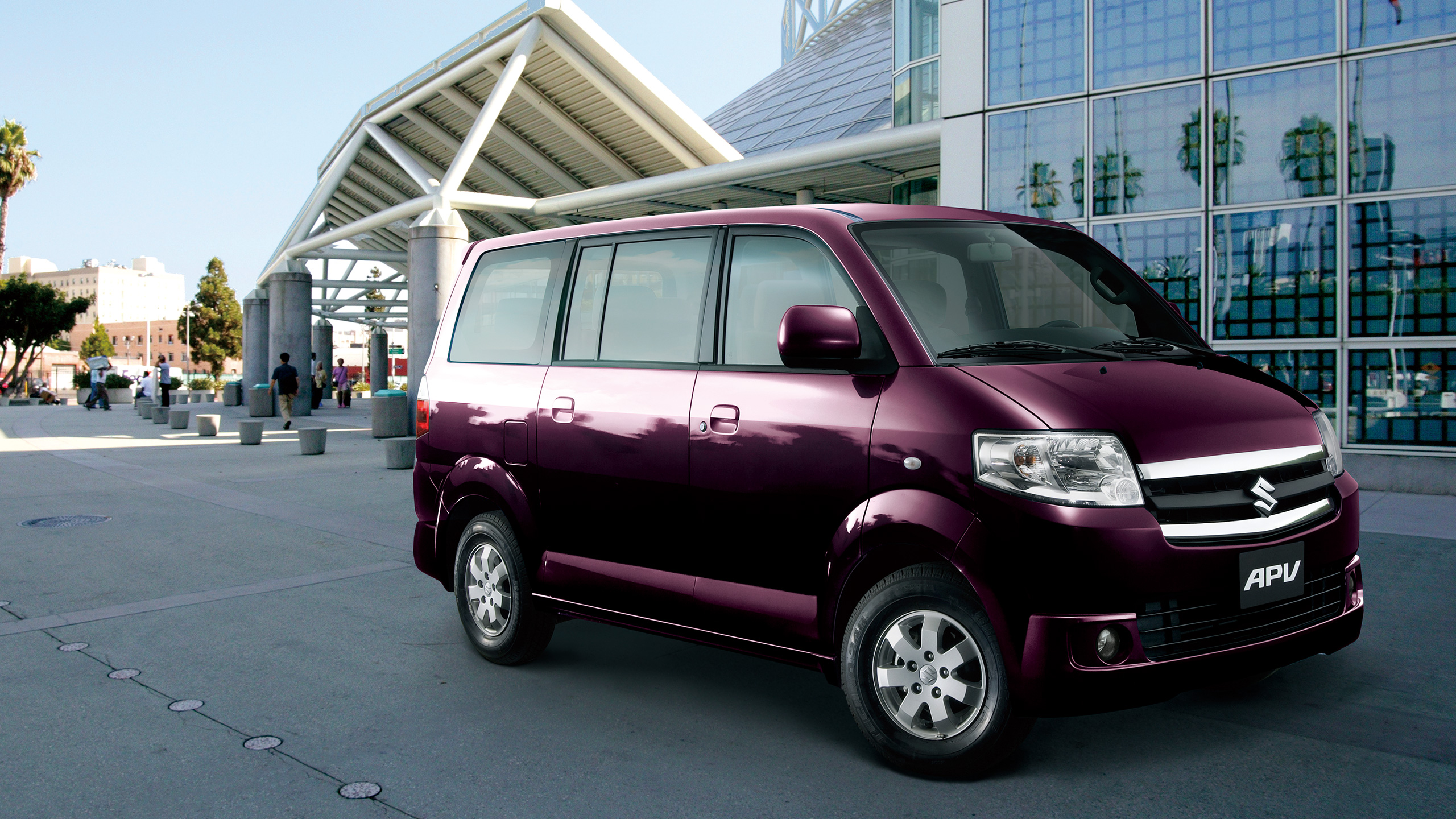 a-purple-APV-parked-in-front-of-a-mirror-building