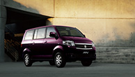 A-purple-Suzuki-APV-parking-in-front-of-an-off-white-concrete-building