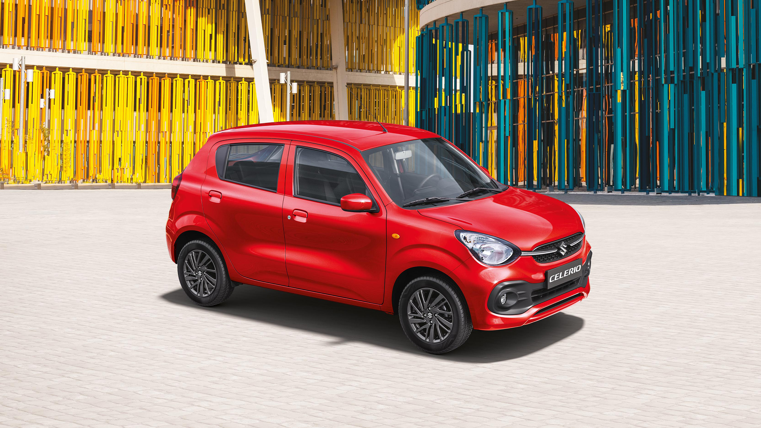 Red-Suzuki-Celerio-standing-in-front-of-a-colourful-architecture