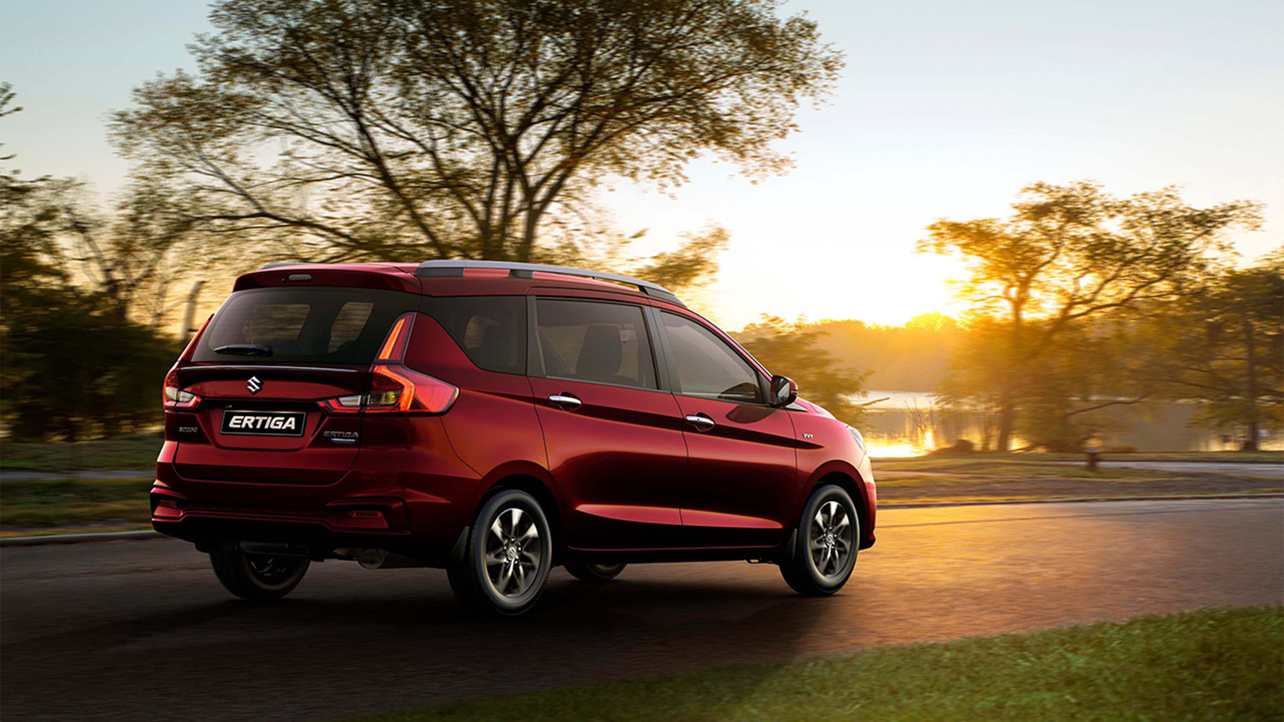 Rear-shot-of red-Suzuki-Ertiga-driving-on-road-in-evening