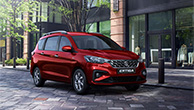 Red-Suzuki-Ertiga-parking-in-front-of-city-building