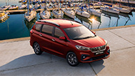 Red-Suzuki-Ertiga-parking-near-yachts