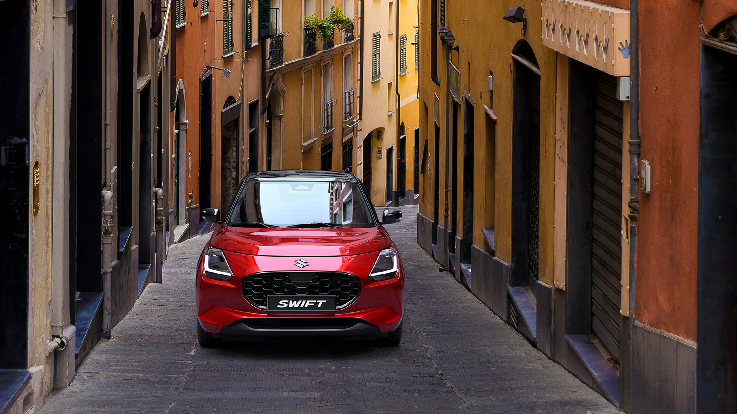 A-red-Swift-runs-along-a-narrow-road