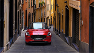A-red-Swift-runs-along-a-narrow-road