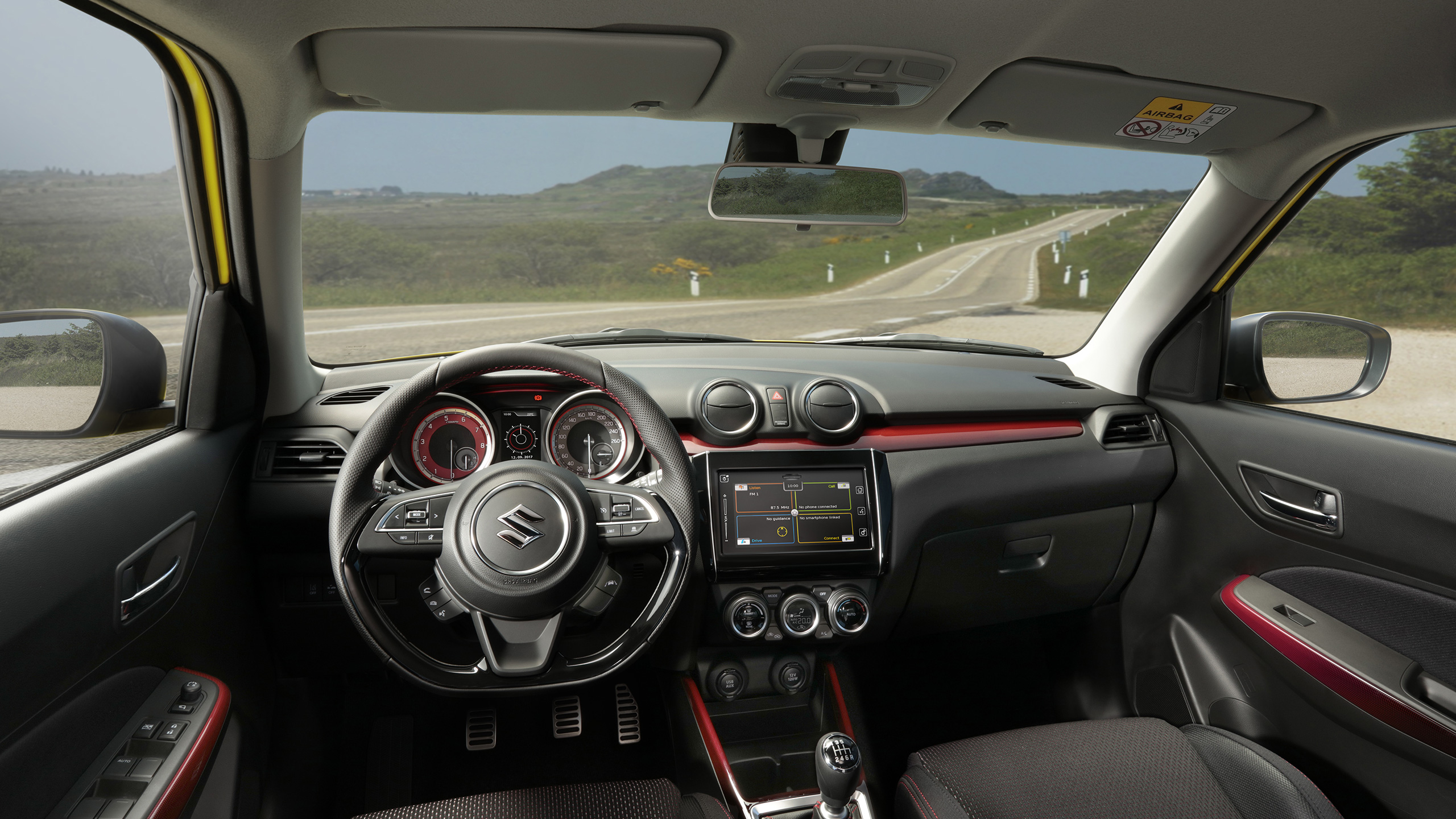 Swift-Sport-interior-showing-instrument-panel-with-highway-outside