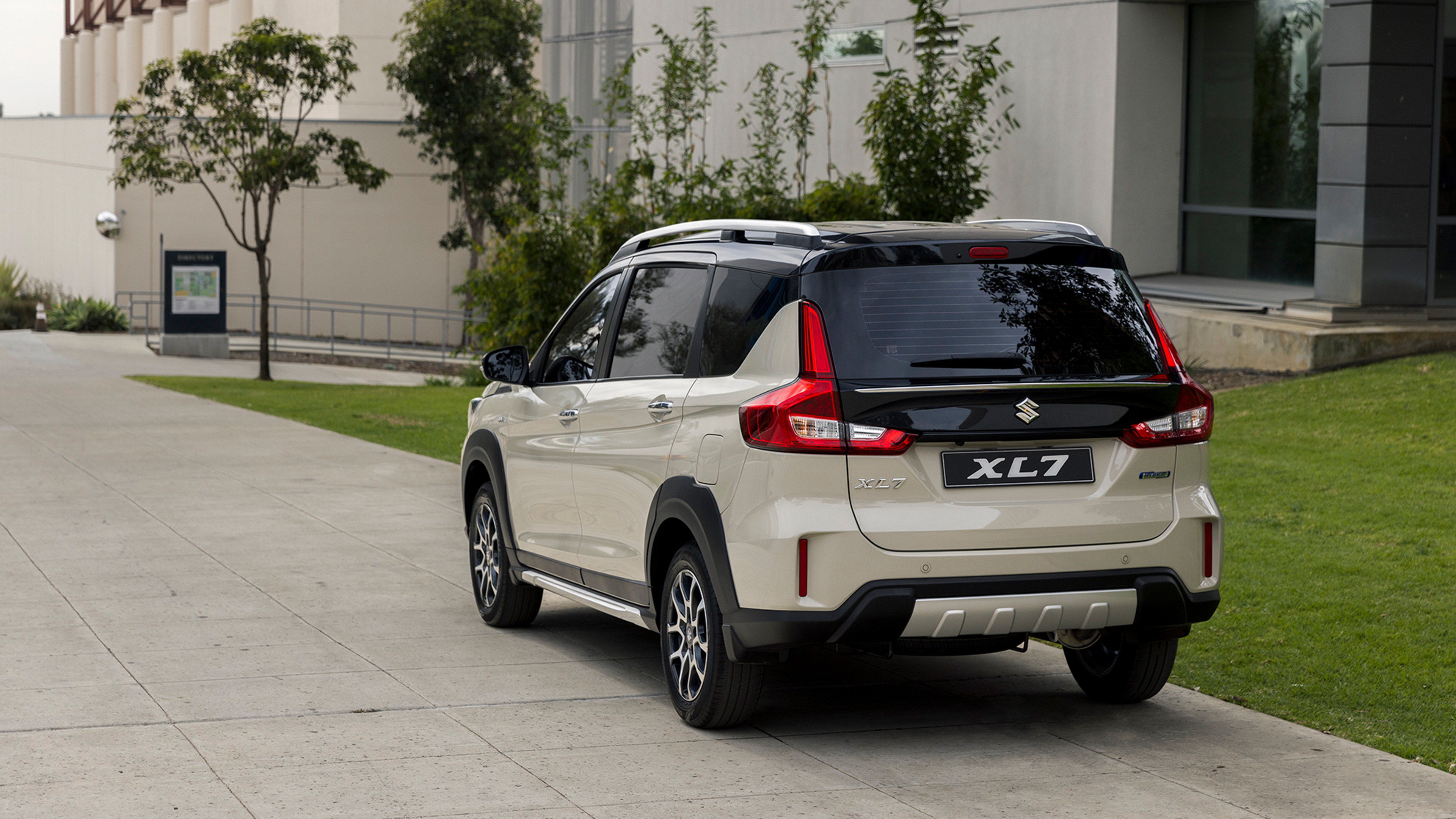 Suzuki-XL7-parked-infront-of-trees-and-building-rear