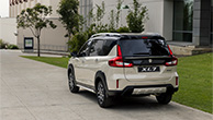 Suzuki-XL7-parked-infront-of-trees-and-building-rear